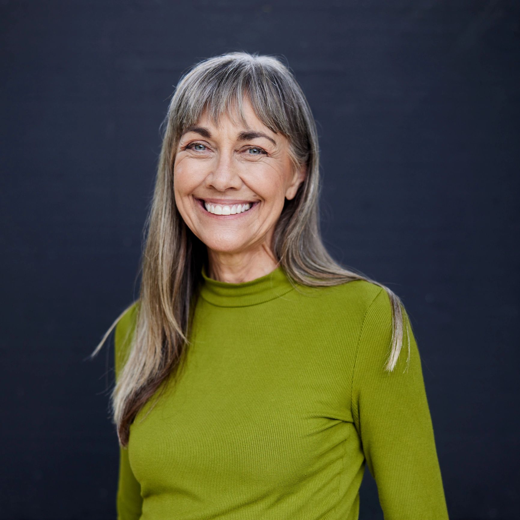 Elegant woman over 50 smiling with calm confidence